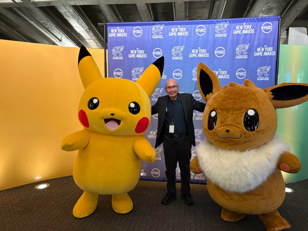 NYVGCC President Harold Goldberg takes a charming photo with Pikachu and Eevee