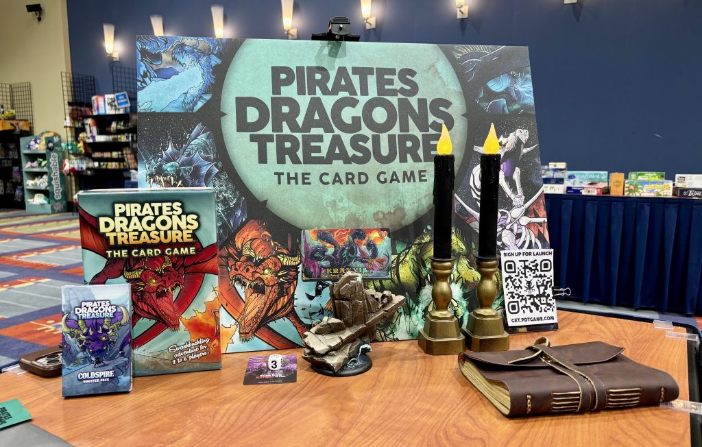 Pirates Dragon Treasure box art poster with two boxes of the newest version of the game and its expansion.